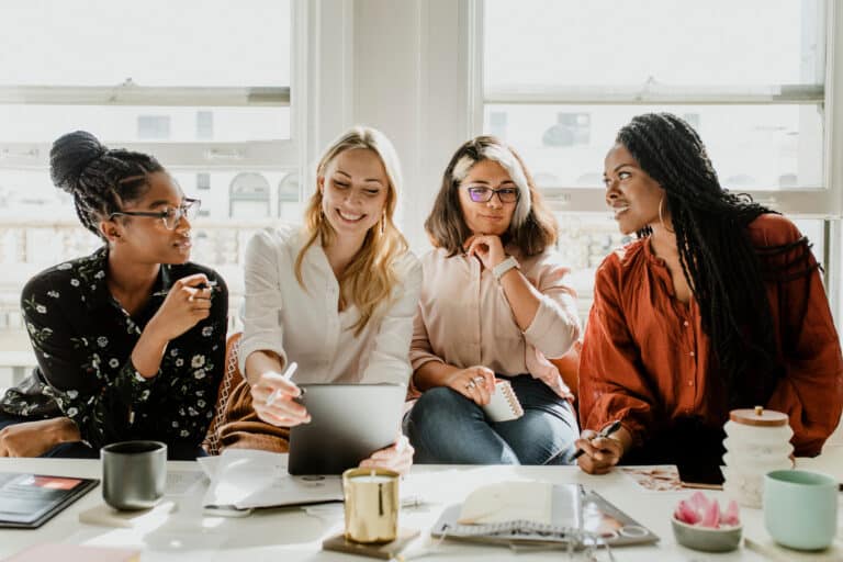 Group of 4 women sitting at a sofa and talking with each other