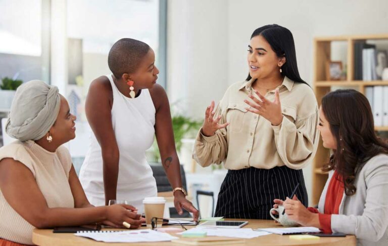 Four women talking around a table