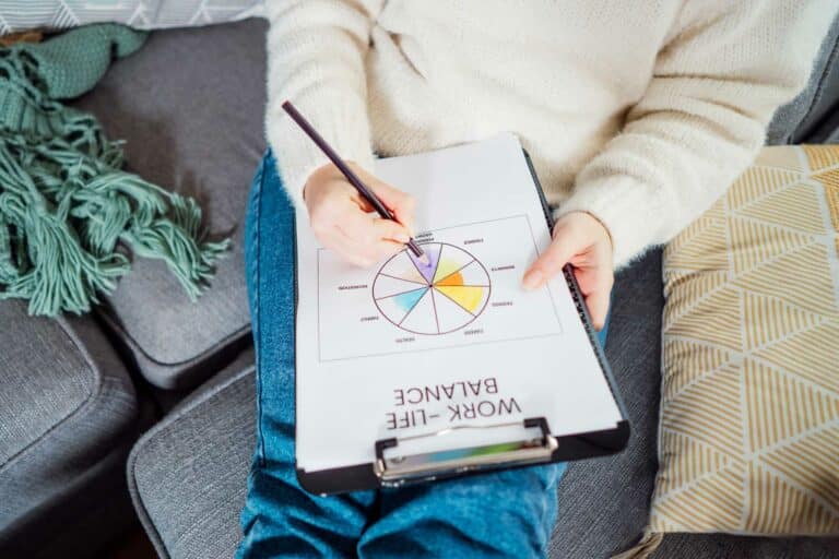Woman holding a clipboard with a "Work-Life Balance" worksheet