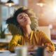 Woman sitting at her desk with her eyes closed and head titled back