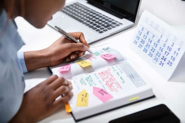 Woman filling out her planner for time management