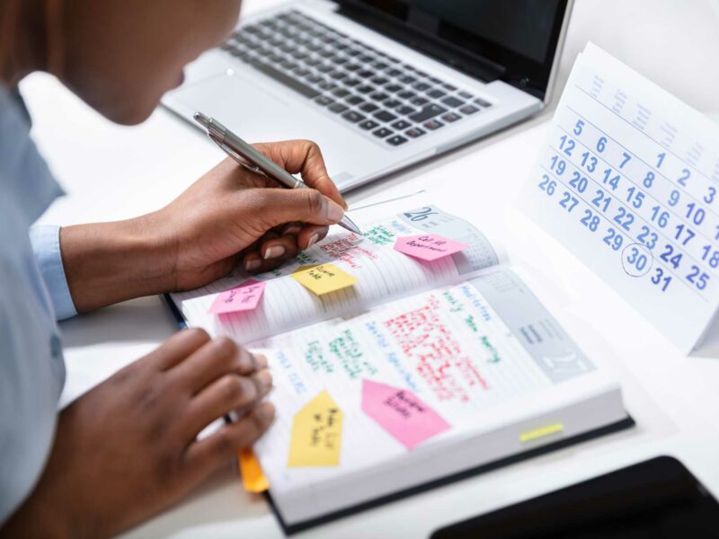 Woman filling out her planner for time management