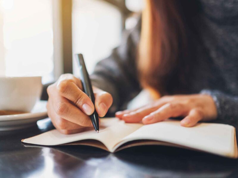 Woman documenting her standard operating procedures in a notebook