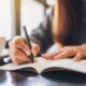 Woman documenting her standard operating procedures in a notebook