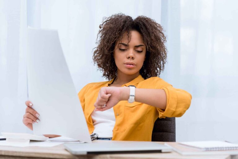 Woman looking at her watch as she implements time management techniques