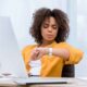 Woman looking at her watch as she implements time management techniques