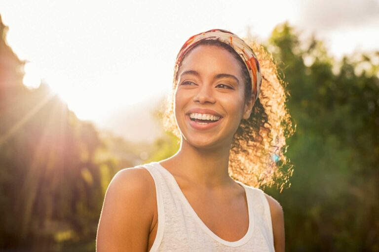 Woman smiling in the sunlight about her mindset shift
