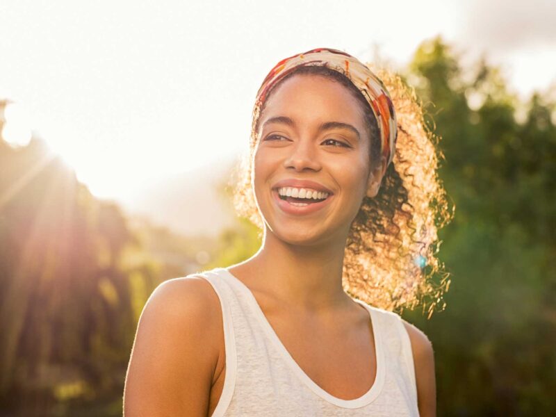 Woman smiling in the sunlight about her mindset shift