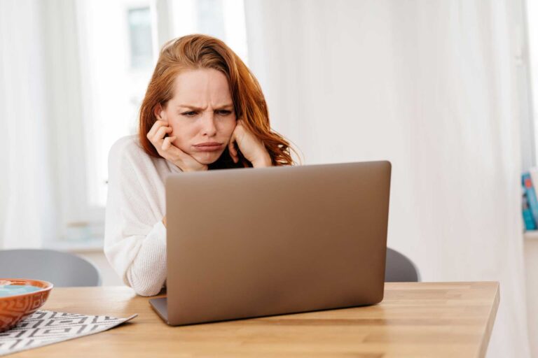 Woman feeling upset about the negative feedback she sees on her computer
