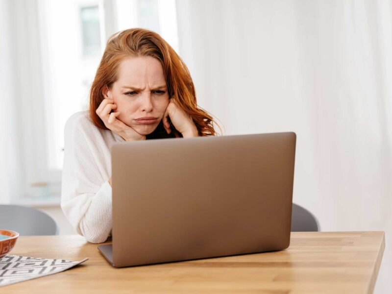 Woman feeling upset about the negative feedback she sees on her computer